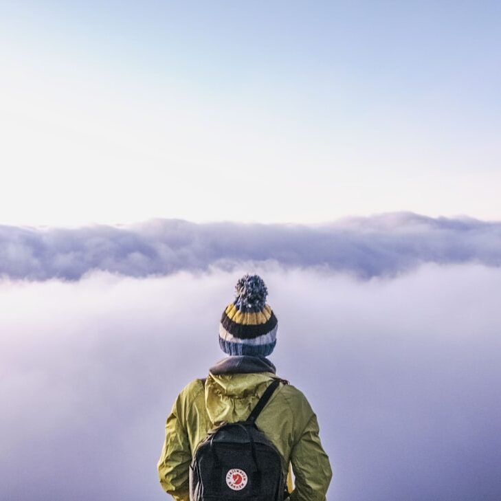 person looking thru sea of clouds